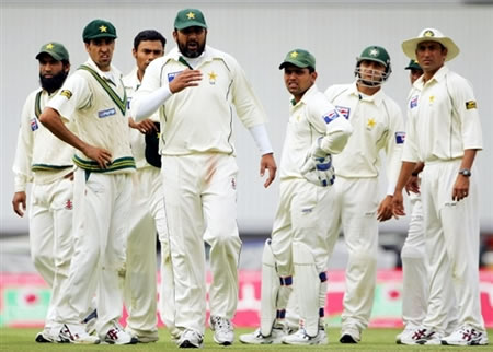 Pakistan team looks concerned as the umpires inspect the ball they think has been tampered