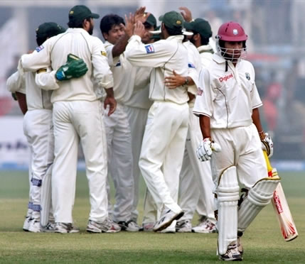 Pakistani players celebrate as Sarwan walk back to the pavilion