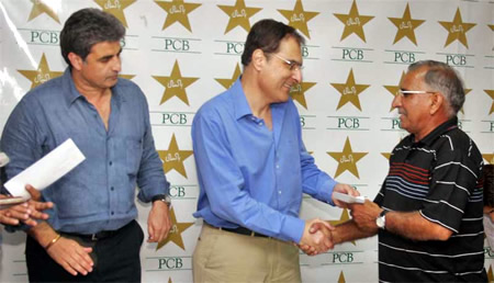 Chief guest Mr. Shafqat Naghmi presents a cheque to retiring umpire Nazir jnr