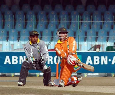 Lions batsman sweeps while Khalid Mahmood watches