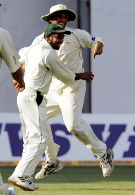 Asim Kamal and Younis Khan celebrate the wicket of Dinesh Karthik