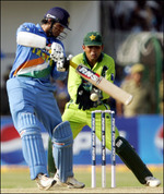 Irfan Pathan plays a stroke as Kamran Akmal looks on