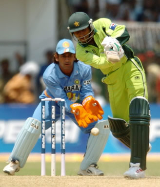 Abdul Razzaq plays a stroke as Mahender Dhoni looks on