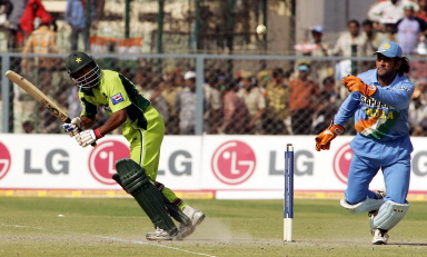 Yousuf Youhana clips a ball to leg past Mahender Dhoni