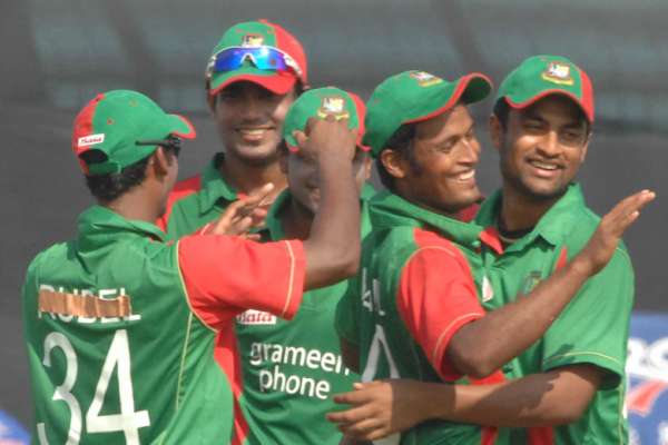 Nazmul Hossain is mobbed by mates after he had taken a spectacular  diving catch at point to get rid of Malcolm Waller