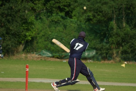 Henry Osinde swings at a ball from Harmanjit Sangha