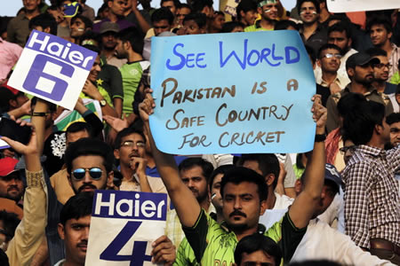 A Pakistan cricket fan holds up a poster