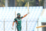 Najmul Hossain Shanto raises his bat after scoring a fifty