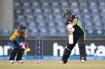 Meg Lanning, Captain of Australia drives the ball with Eshani Lokusuriyage of Sri Lanka looking on