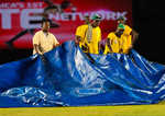 The groundsmen getting ready with the covers