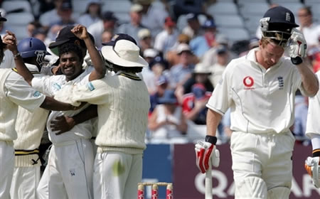 Muralitharan celebrates as Collingwood walks back to the pavilion